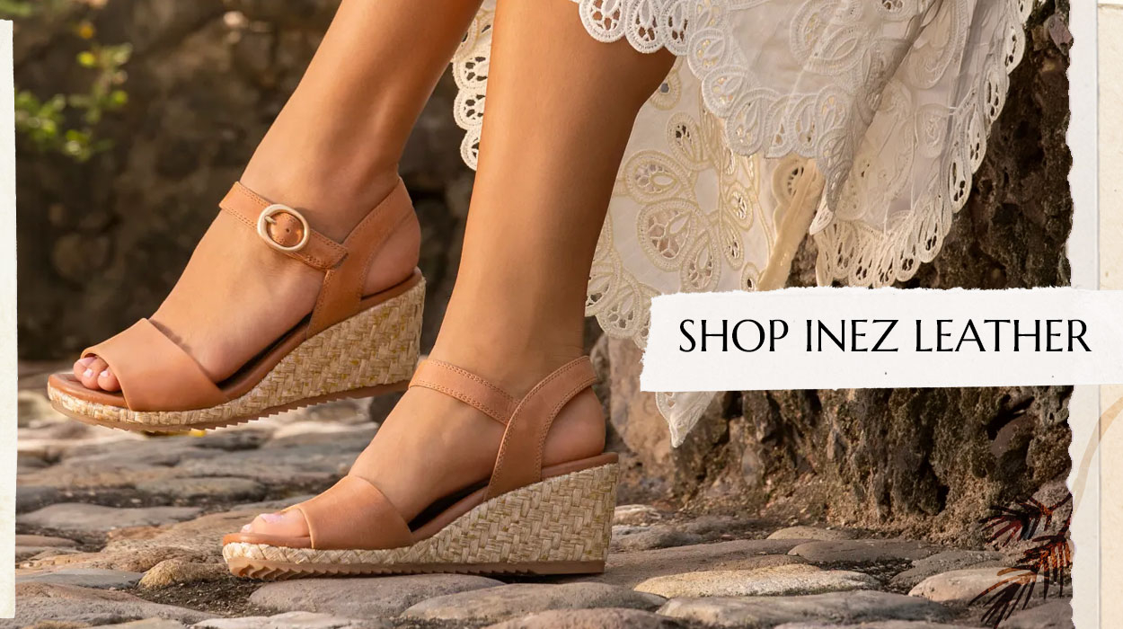 Woman in a white dress sitting wearing the Inez leather in tan. Shop Inez Leather.