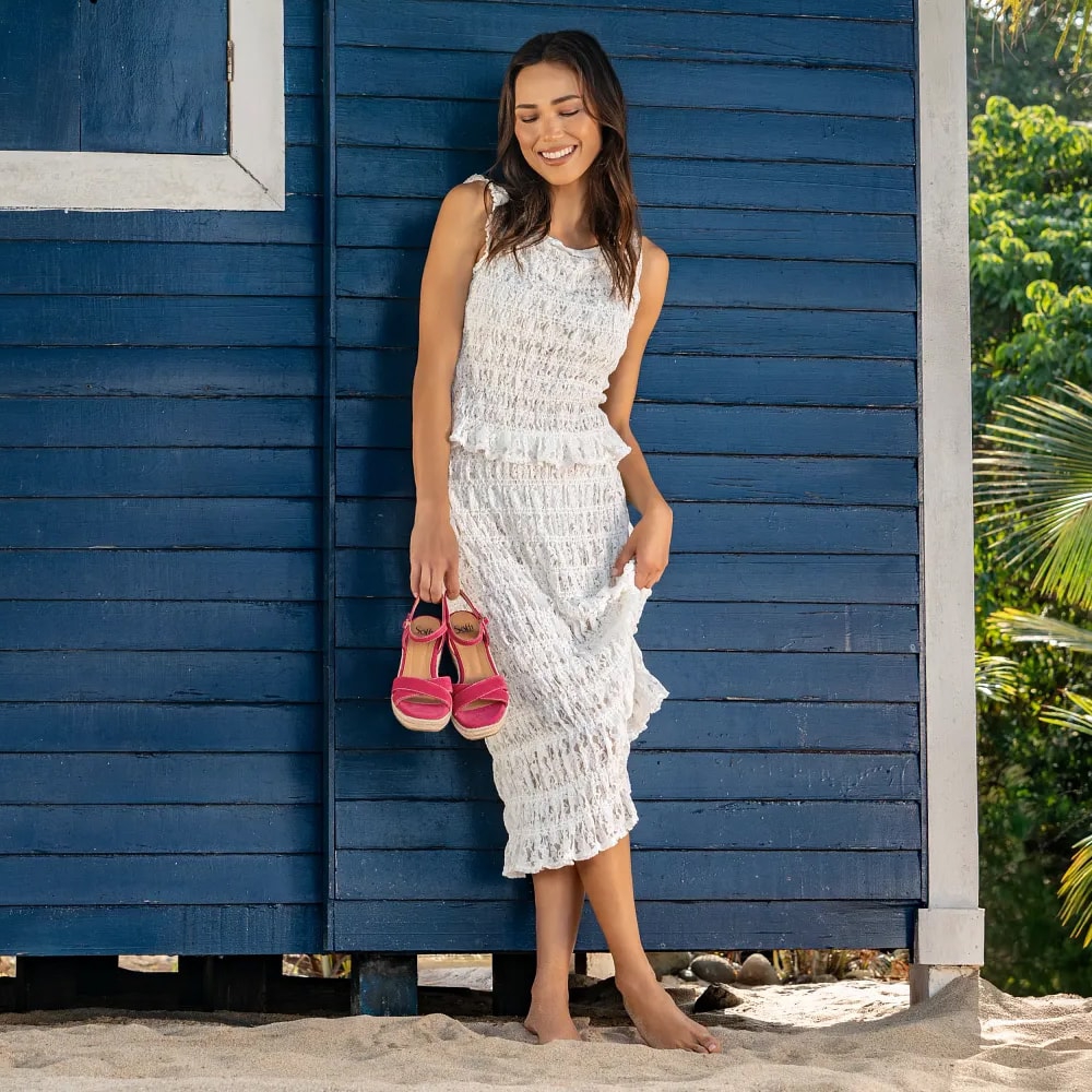 Montage of a model holding a pair of the Neely sandal in red against a blue background, a close up of the Elsa sandal in blue on a white chair and a close up of a model wearing the the Kelly maryjane on tennis court.