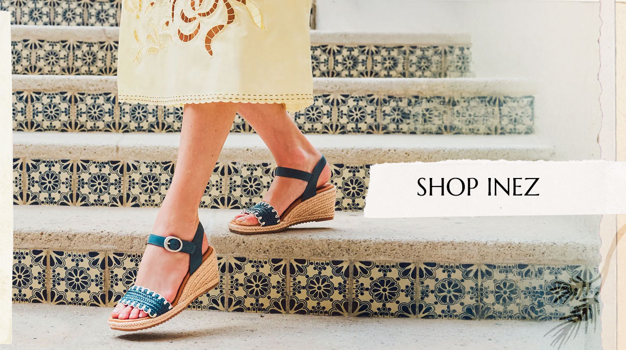 Woman walking down steps wearing the INez sandal in blue. Shop Inez.